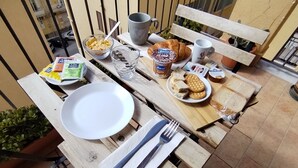 A wooden table set with breakfast items including cereal, bread, and a plate of cookies. - Home La Kore (Agrigento)