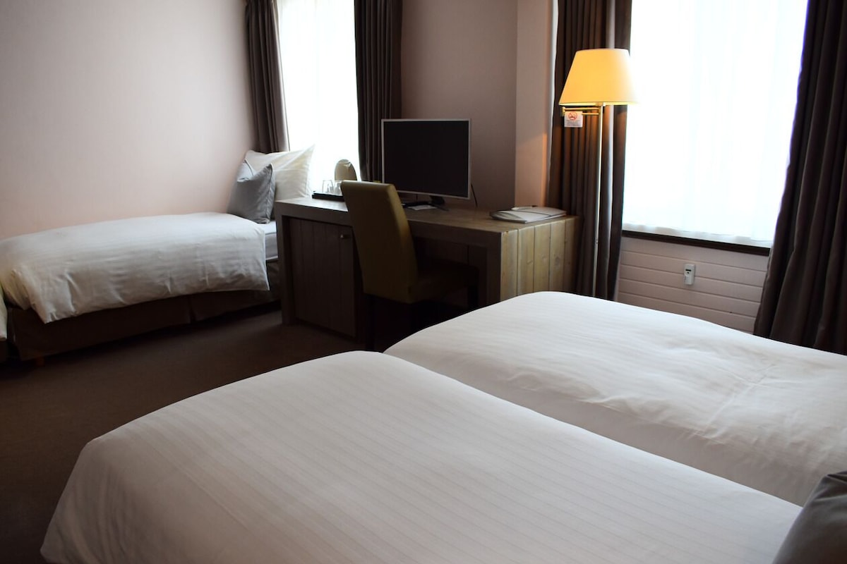 Minibar, escritorio, cortinas blackout y tabla de planchar con plancha 