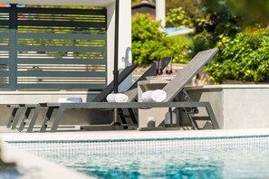A poolside area with lounge chairs, towels, and a wicker basket. - Summer Breeze Apartments (Novalja)