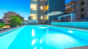 Piscina externa sazonal, funciona das 9h às 21h, guarda-sóis