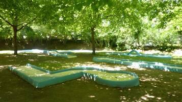 Un parque con senderos verdes y árboles.