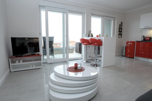 Departamento Deluxe, 2 habitaciones, vista al mar | Área de sala de estar | Televisión de pantalla plana de 45 pulgadas con canales vía satélite 
