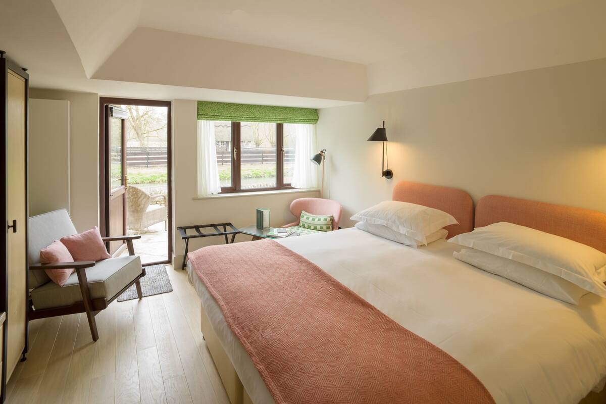 Une chambre à coucher avec un lit, une chaise, une table et une fenêtre.