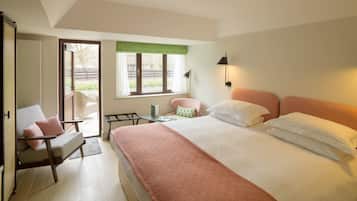 Un dormitorio con cama, una silla, una mesa y un ventanal.