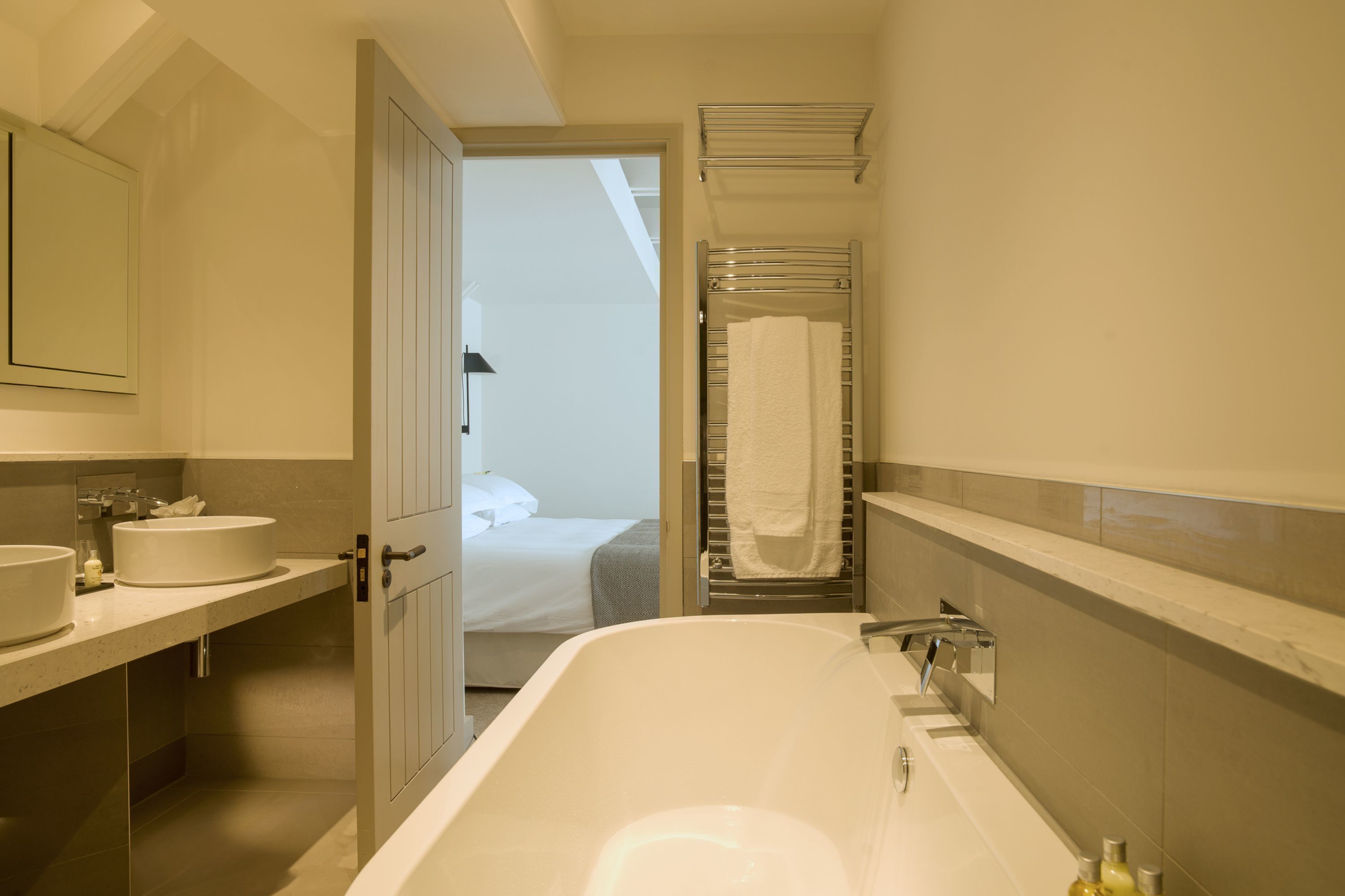 Un baño moderno con una bañera grande, un lavabo doble y una ducha a ras de suelo.