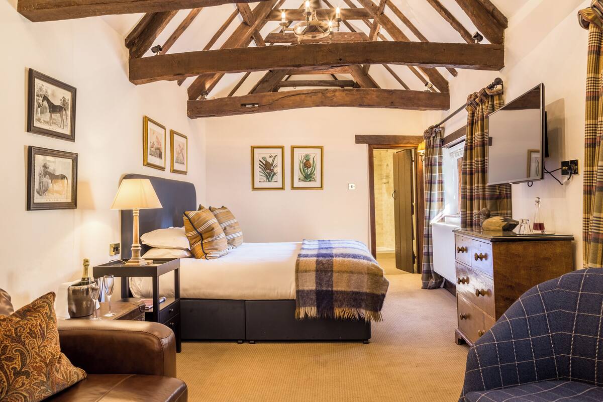 Une chambre à coucher avec un lit, une table de chevet, une lampe et une commode.