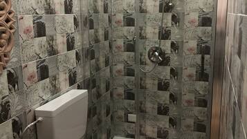 A bathroom with a shower, toilet, and sink.