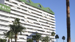 A multi-story hotel with a green roof and balconies. - Apartamentos Esmeralda (Calpe)
