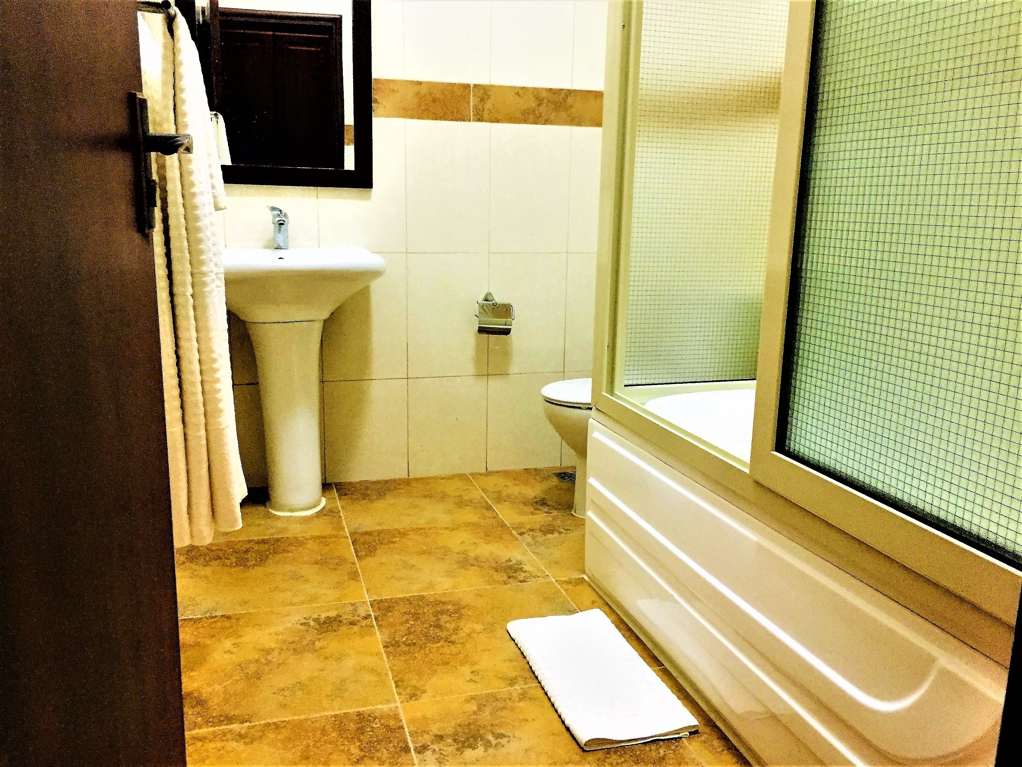 A bathroom with a sink, toilet, and bathtub.