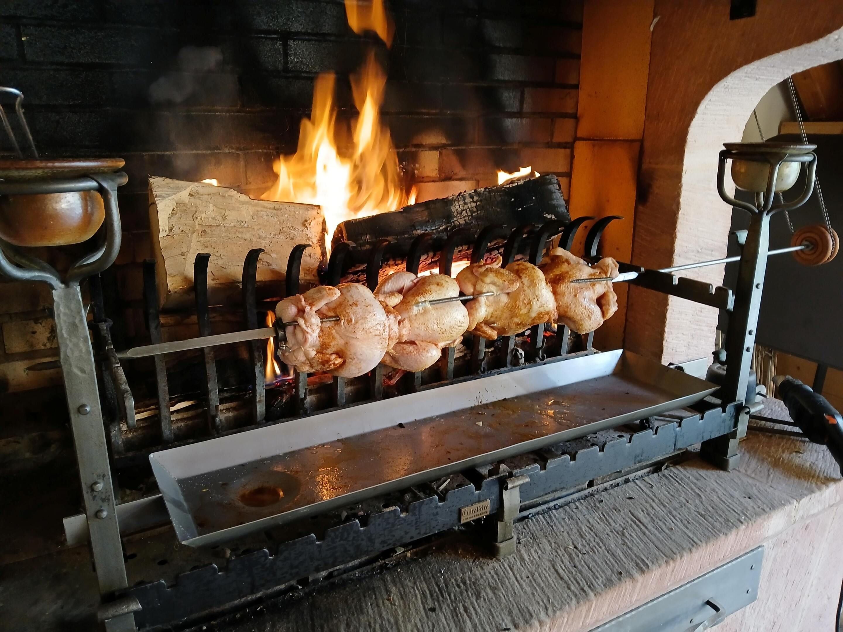Ein Drehspieß mit Feuer im Hintergrund.