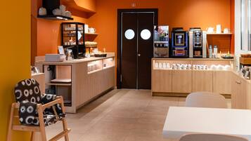 Ein modernes Café mit Holztresen, Sitzgelegenheiten und Kaffeemaschinen.