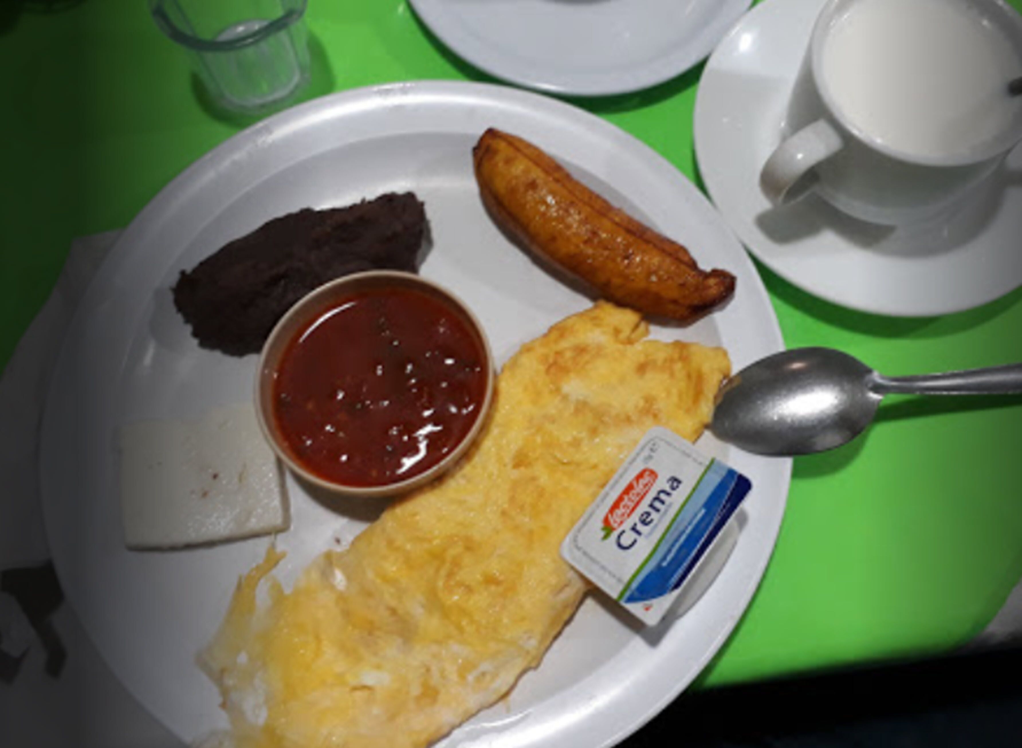 Ein Teller mit einem Schokoladendessert, einer frittierten Speise, einem Omelettstück und einer kleinen Portion Creme.