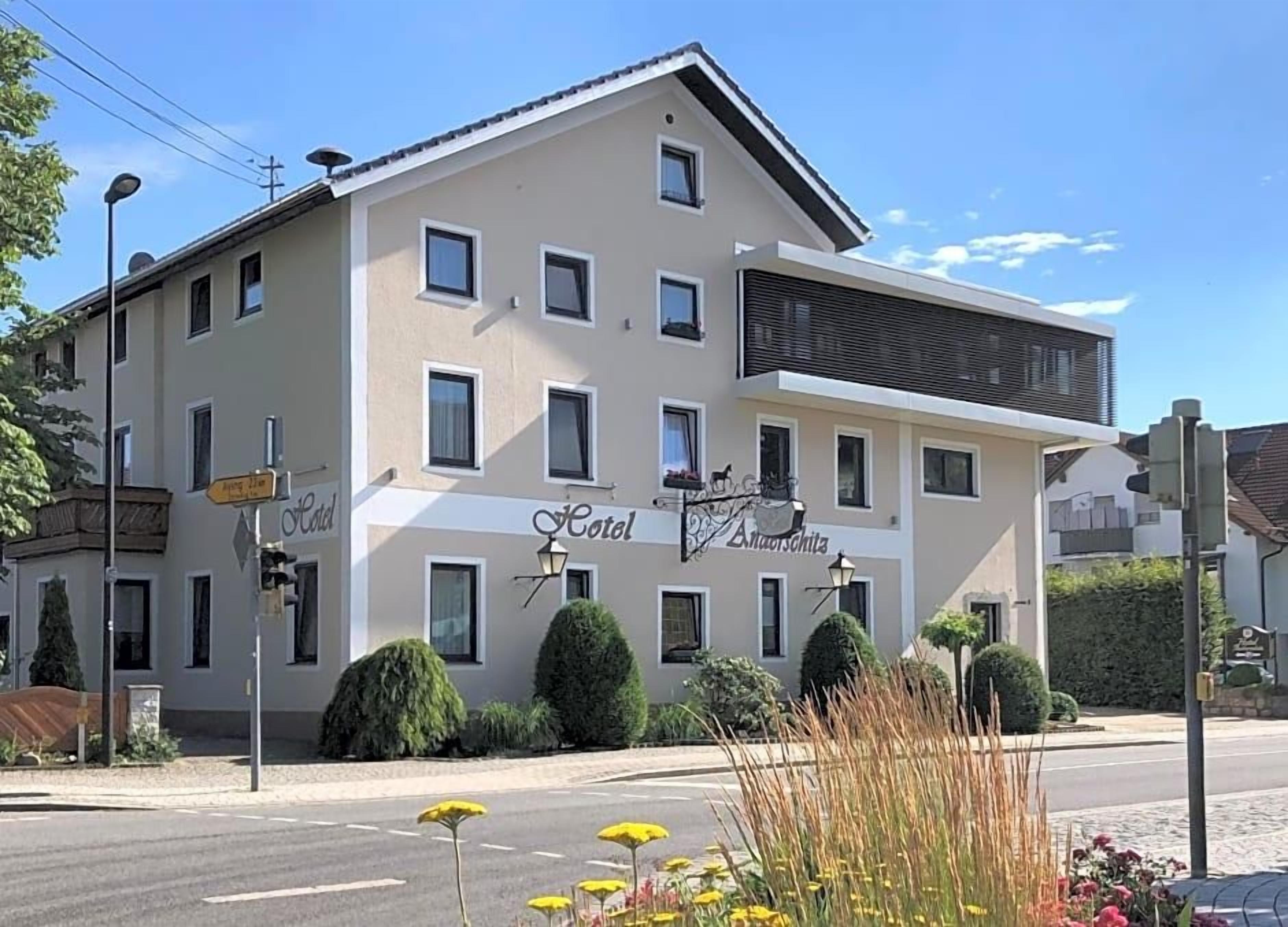 A hotel with a flat facade, multiple windows, and a sign indicating it is a hotel.
