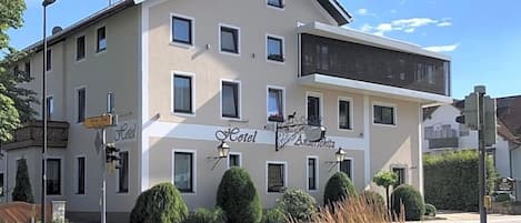 A hotel with a flat facade, multiple windows, and a sign indicating it is a hotel.