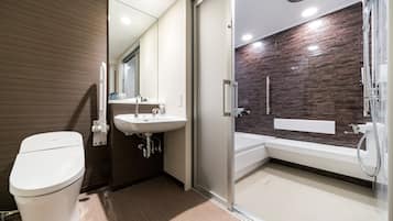 Un baño moderno con inodoro, lavamanos y zona de ducha.