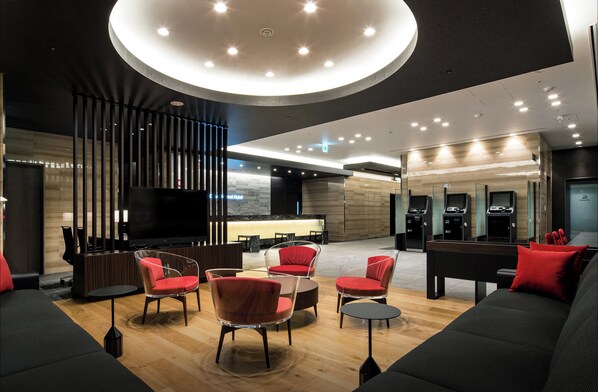 A modern hotel lobby with a central seating area, a reception desk, and a large flat-screen TV. - Daiwa Roynet Hotel Hiroshima Station (Hiroshima)
