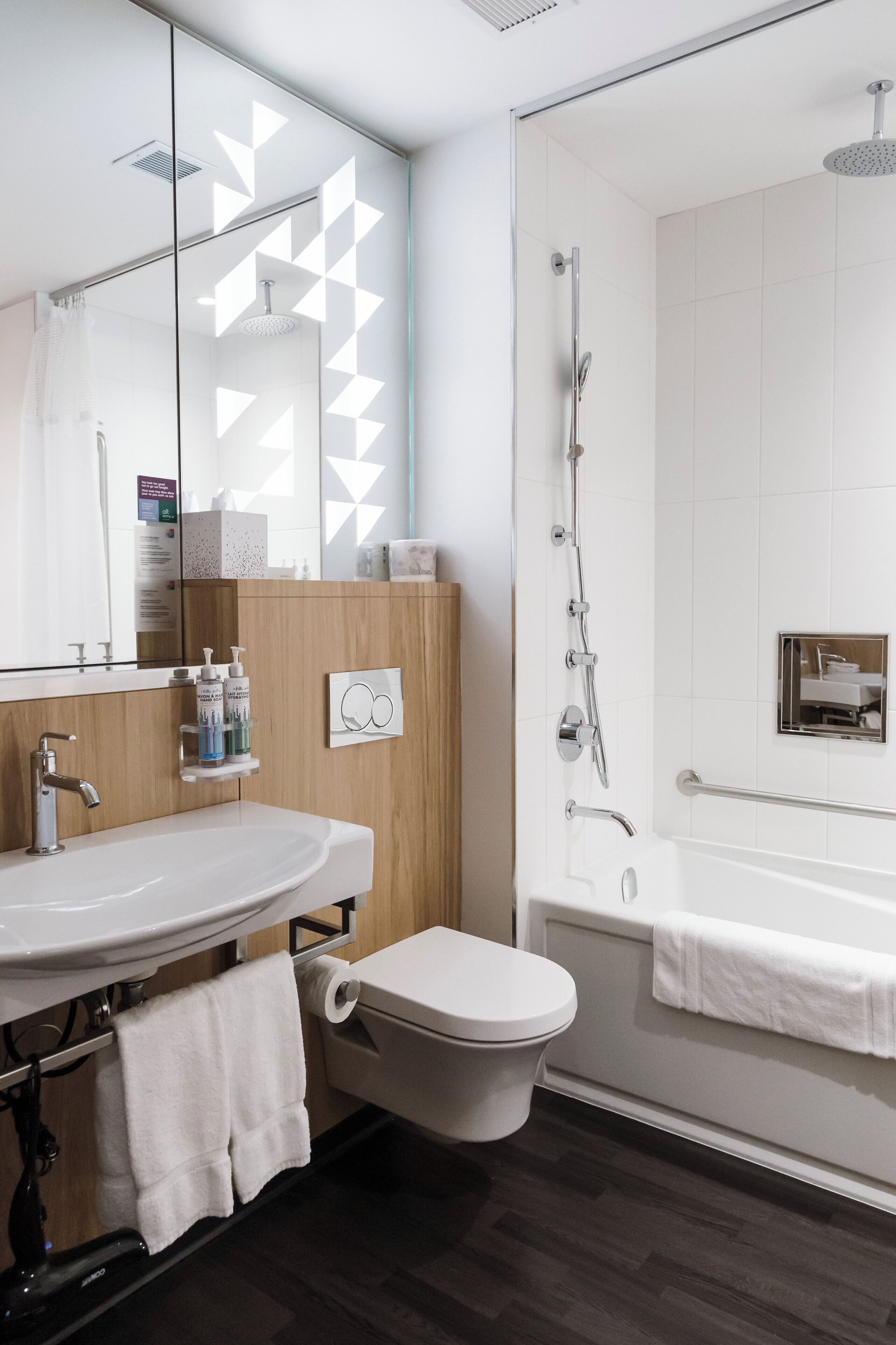 A modern bathroom with a vanity, toilet, and shower.