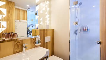 Une salle de bain moderne avec un meuble-lavabo en bois, une cabine de douche en verre et un grand miroir.