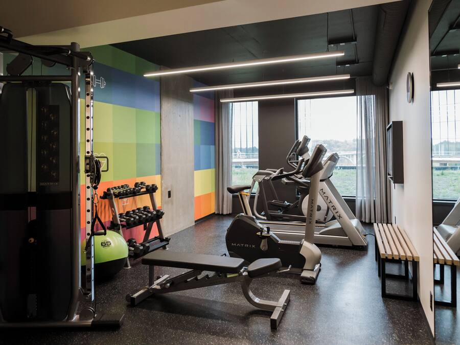 A gym with cardio equipment, weight machines, and dumbbells.