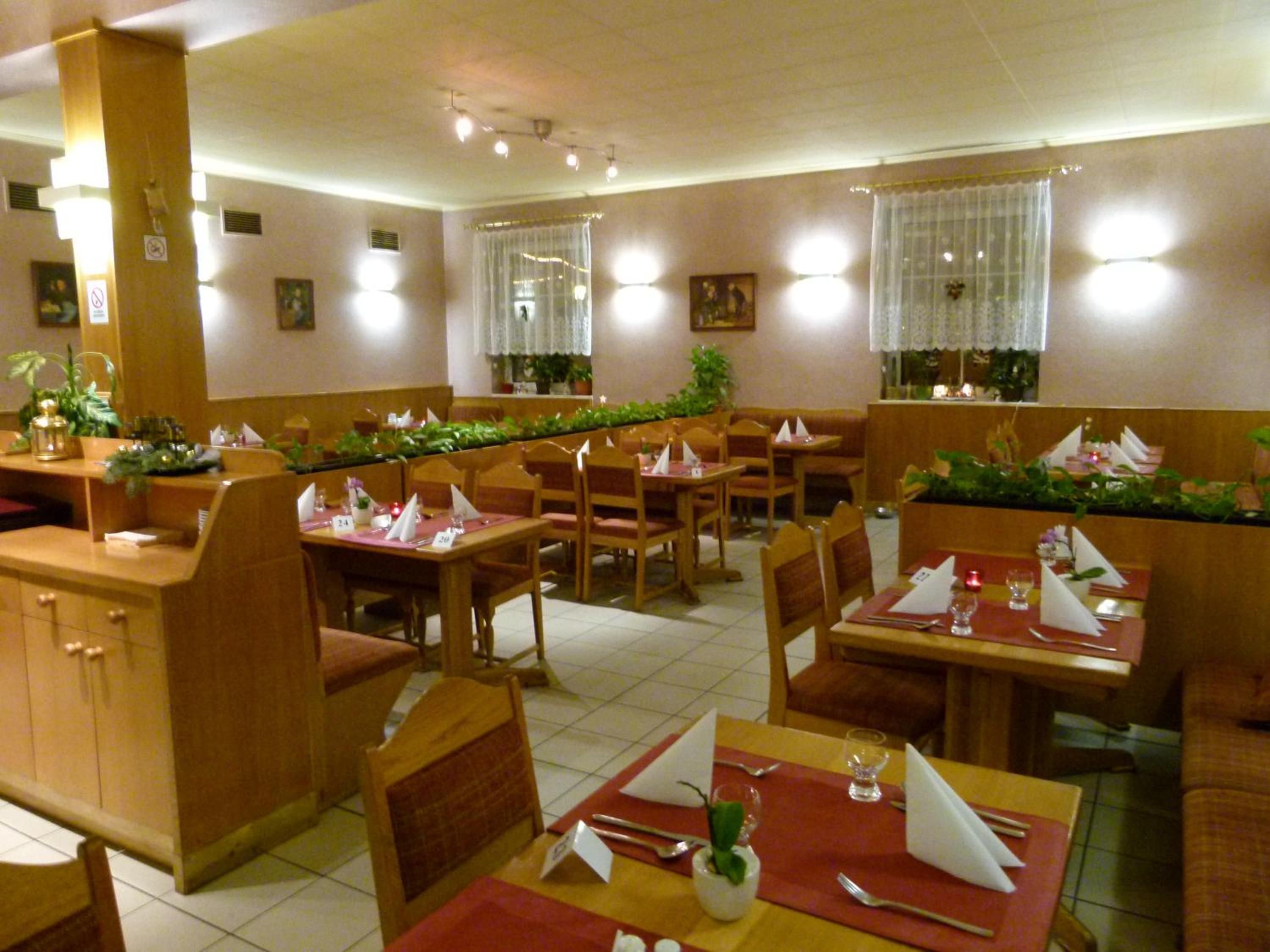 Un restaurante con cabinas y mesas, algunas con menús y vasos.