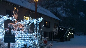 A building with snow-covered surroundings and illuminated decorations. - Auberge Gaillard (La Motte-en-Champsaur)