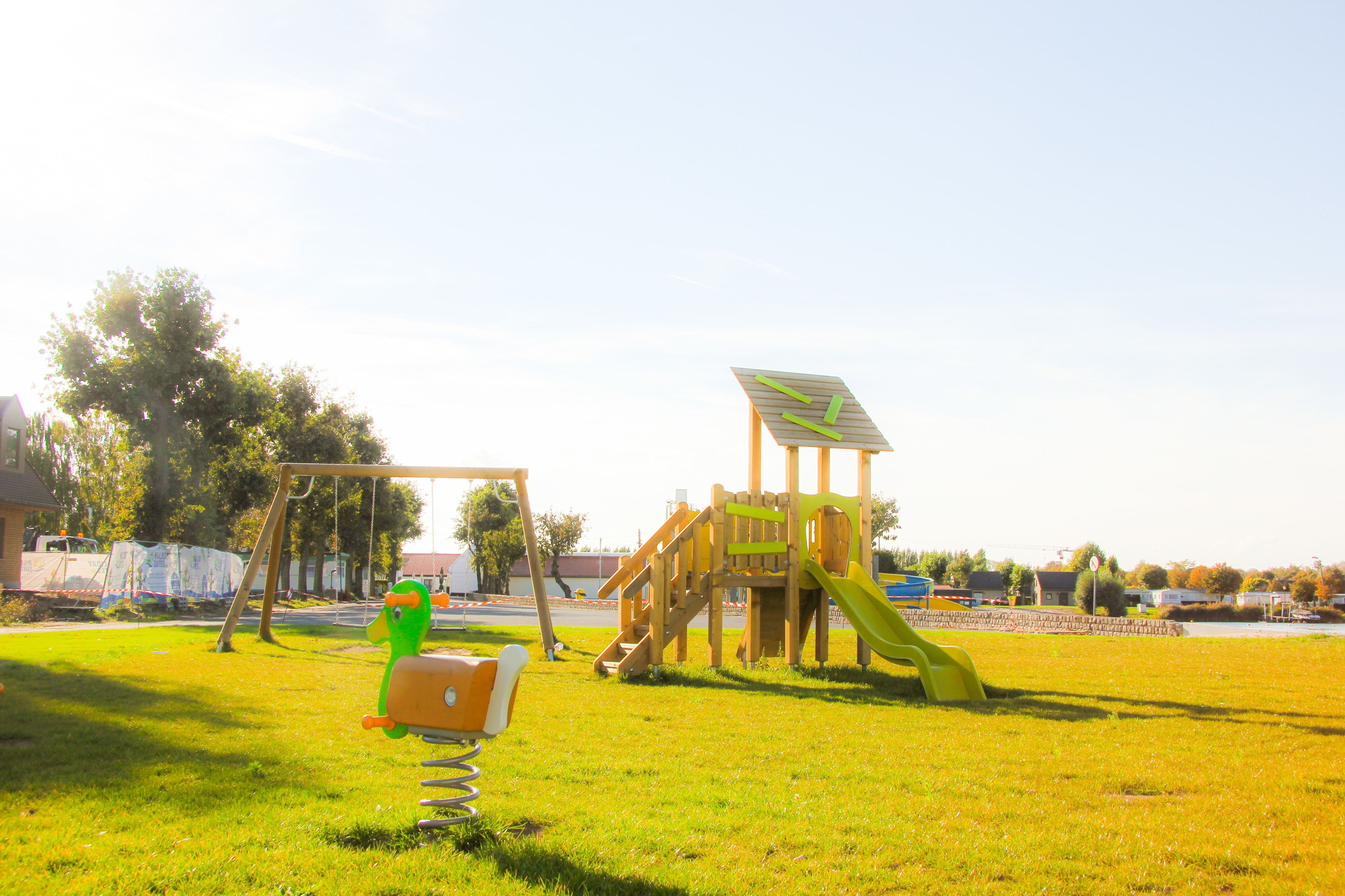 A playground with a slide and swings.