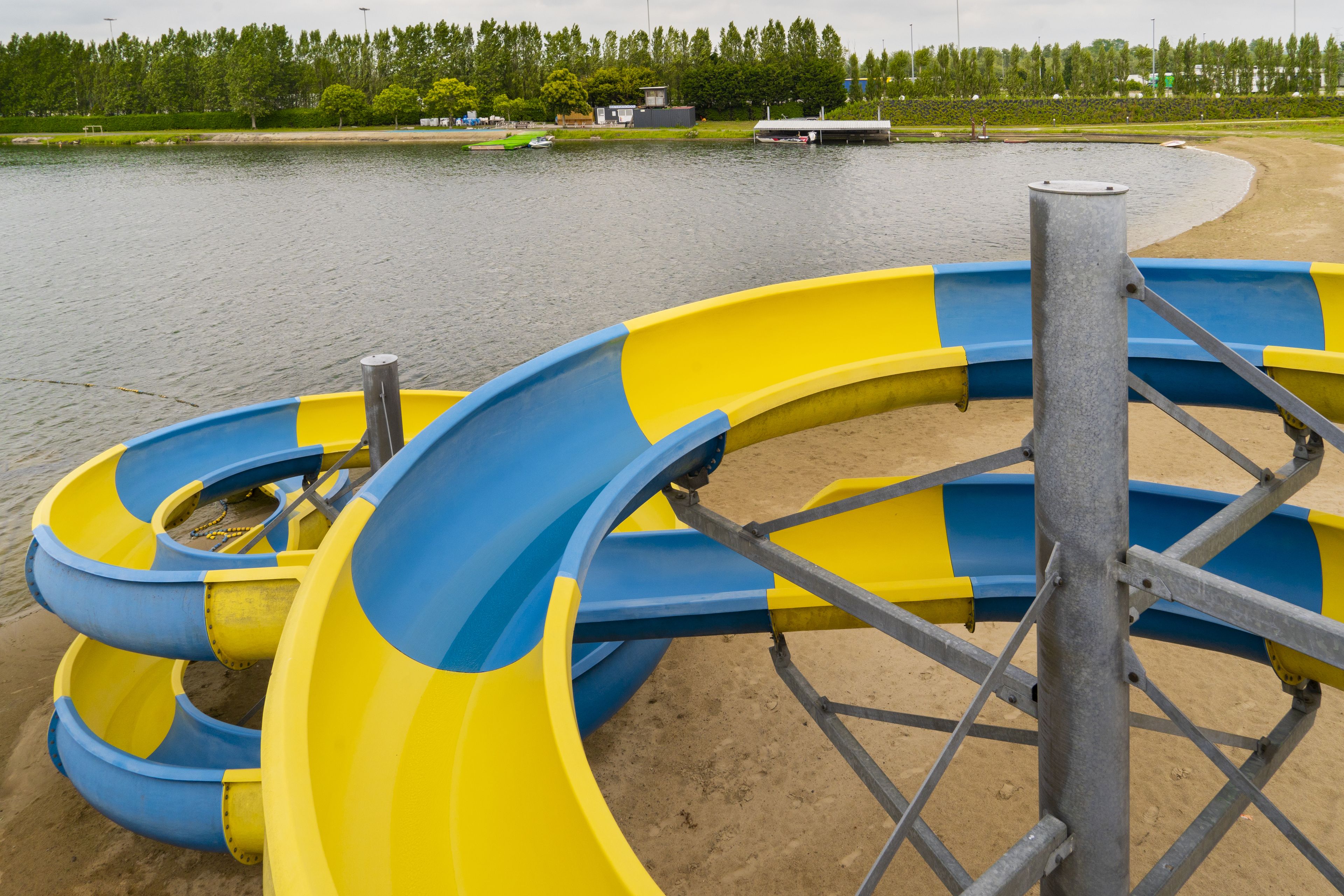 A water park with a large yellow and blue water slide.