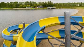 A water park with a large yellow and blue water slide.
