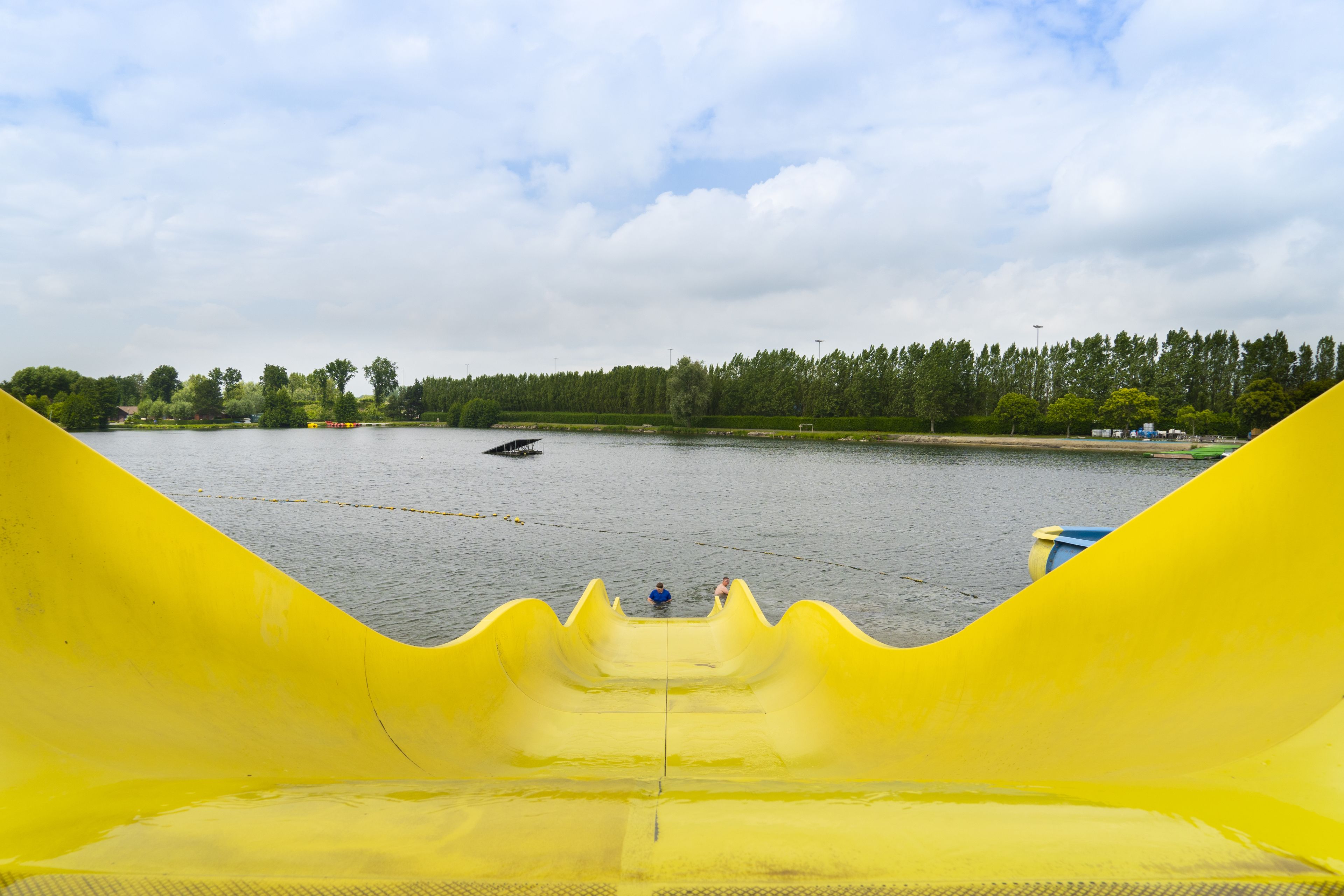 A water slide with a view of a lake and a forested area in the background.