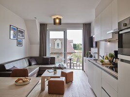 Un apartamento moderno con sala de estar, cocina y balcón.