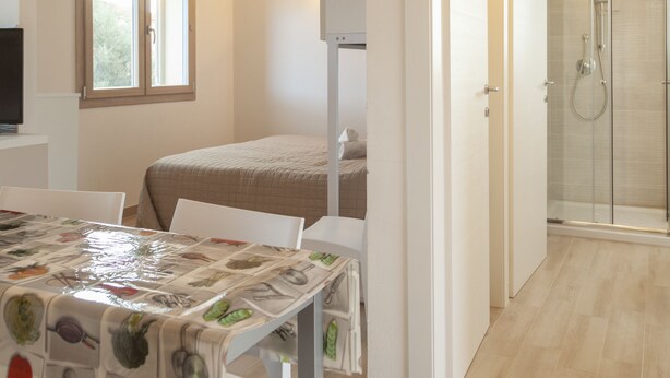Un dormitorio con cama, ducha y una mesa con mantel.
