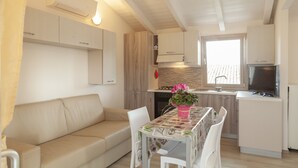 Una cocina compacta con comedor, un sofá y un televisor.
