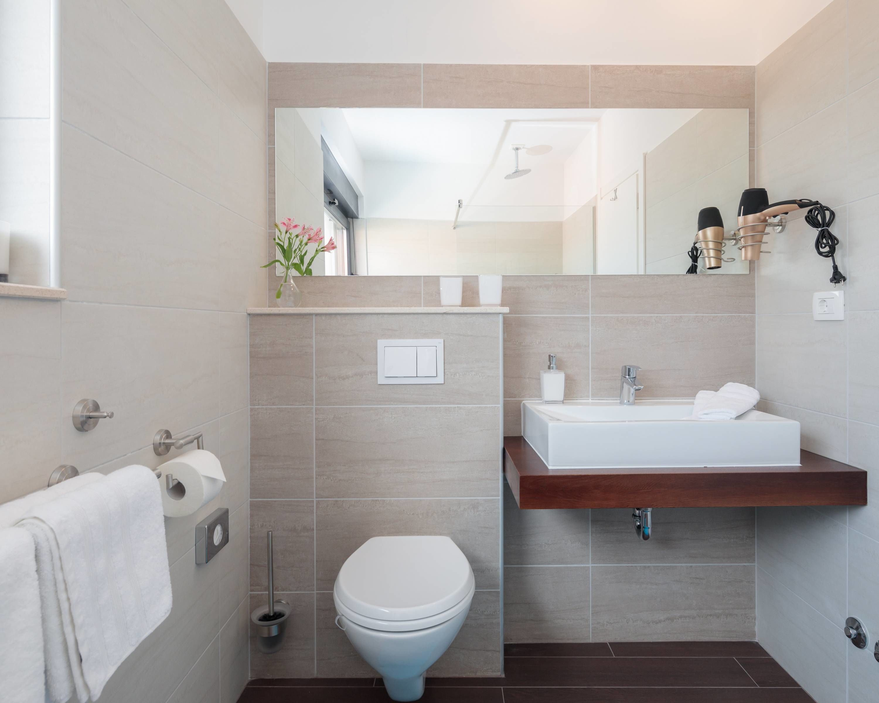 A modern bathroom with a toilet, sink, and shower.