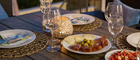 Une table mise pour un repas, avec des assiettes remplies de nourriture, des verres à vin et des couverts.