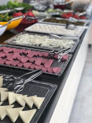 Un bufé con diversos alimentos dispuestos en bandejas.