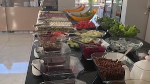 A buffet with various food items and a Coca-Cola refrigerator in the background. - Kaptan Suit Otel (Silifke)