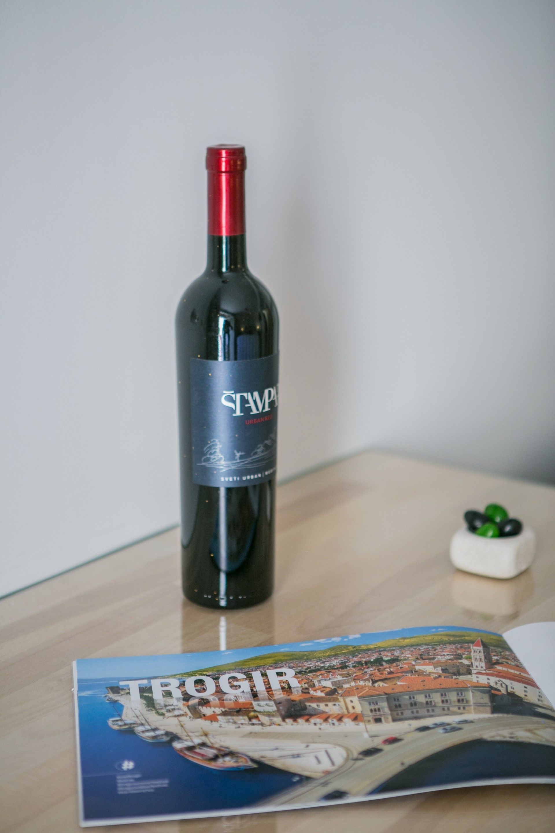 Une bouteille de vin Stampa et une brochure sur une table.