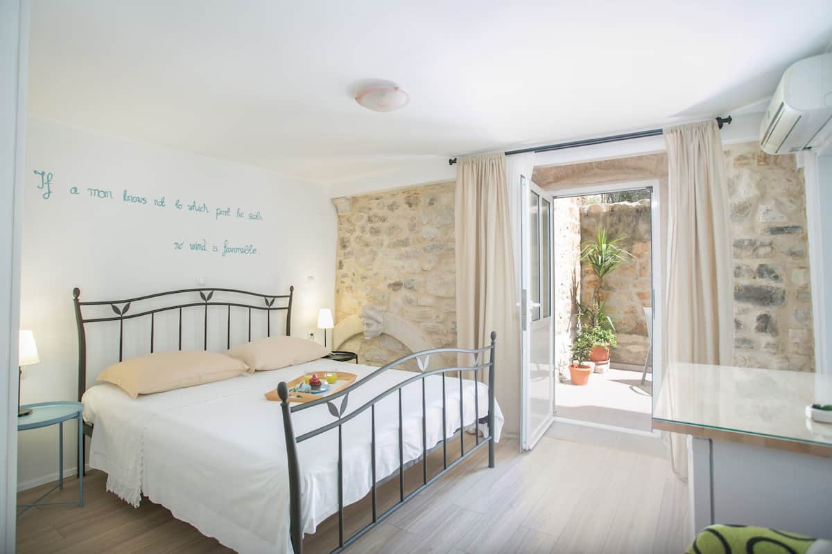 Un dormitorio con cama, mesita de noche y vistas al exterior.