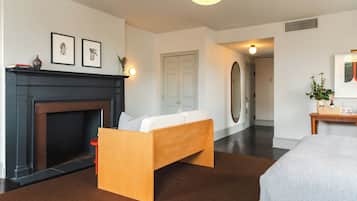 Una habitación moderna con chimenea, una cama, un banco y una puerta que da a otra habitación.