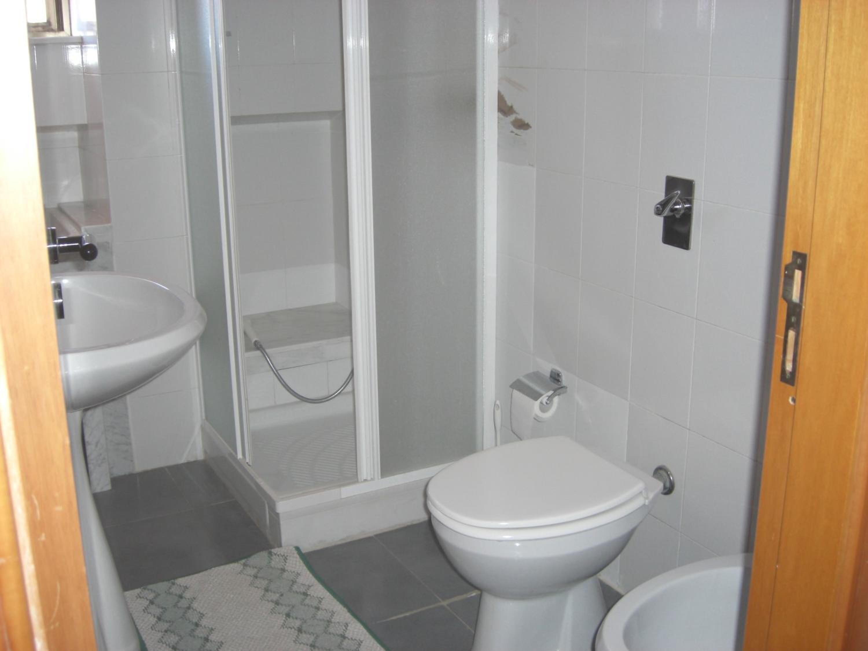 Un baño con inodoro, bidé y ducha.