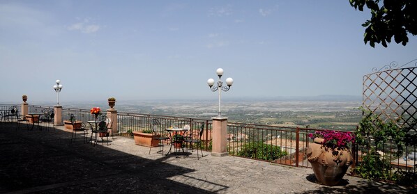 A terrace with outdoor seating, a view of the countryside, and decorative lighting. - Albergo villa nobile (Chiaramonte Gulfi)
