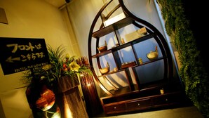 A traditional Japanese room with a tatami mat floor, a wooden cabinet with a glass display, and a sign with Japanese characters. - Hotel The Lotus Bali - Adult Only (Kawasaki)
