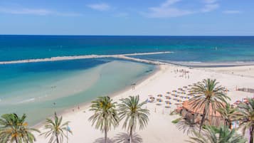 Na praia, guarda-sóis, toalhas de praia, bar na praia 