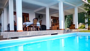 Una piscina con un área de patio techada.