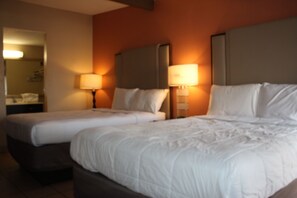 Une chambre d’hôtel avec deux lits, chacun doté d’une tête de lit et de lampes de chevet.