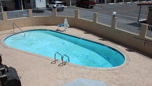 Une piscine rectangulaire avec un échelle en métal et un petit bateau.
