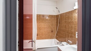 Un baño con bañera, ducha y lavamanos.