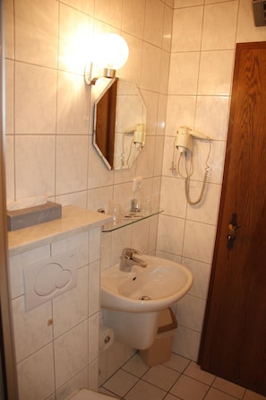 Un baño con lavamanos, espejo y secador de pelo.