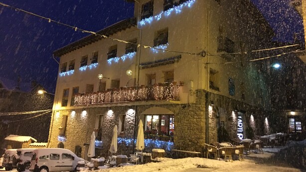 Un hotel con fachada de piedra, varios balcones y zonas de estar al aire libre.