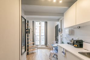 Une cuisine moderne équipée d’une cuisinière intégrée, d’un évier et d’une fenêtre donnant sur un balcon.